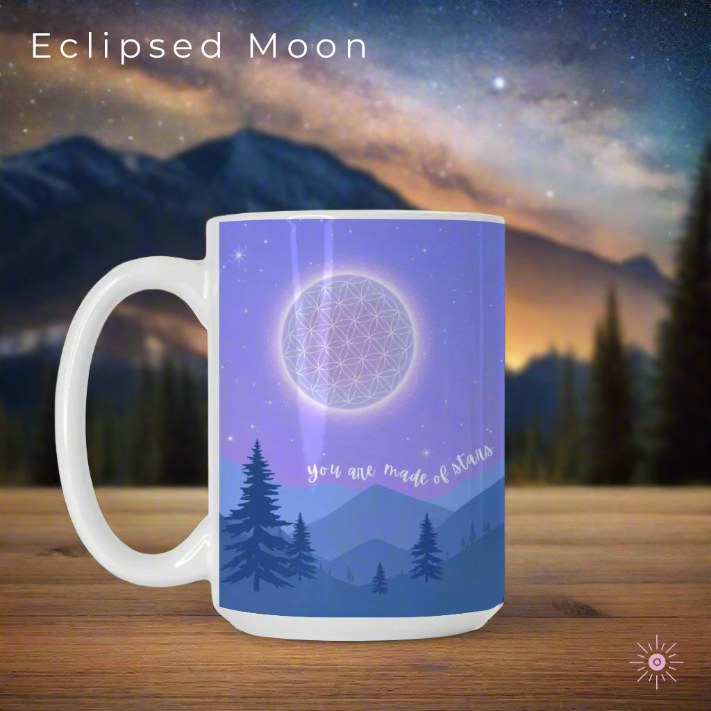 Ceramic mug featuring a starry night sky over mountains, with the Flower of Life as the moon, a commemorative comet, and the phrase 'You are made of stars - BE THE LIGHT' inspiring mindfulness and cosmic connection.
