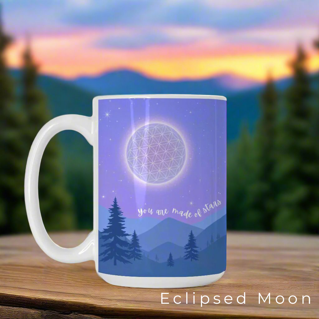 Ceramic mug featuring a starry night sky over mountains, with the Flower of Life as the moon, a commemorative comet, and the phrase 'You are made of stars - BE THE LIGHT' inspiring mindfulness and cosmic connection.